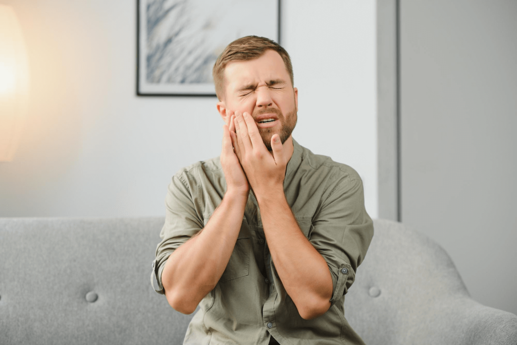 Man holding his jaw in pain because of a toothache.